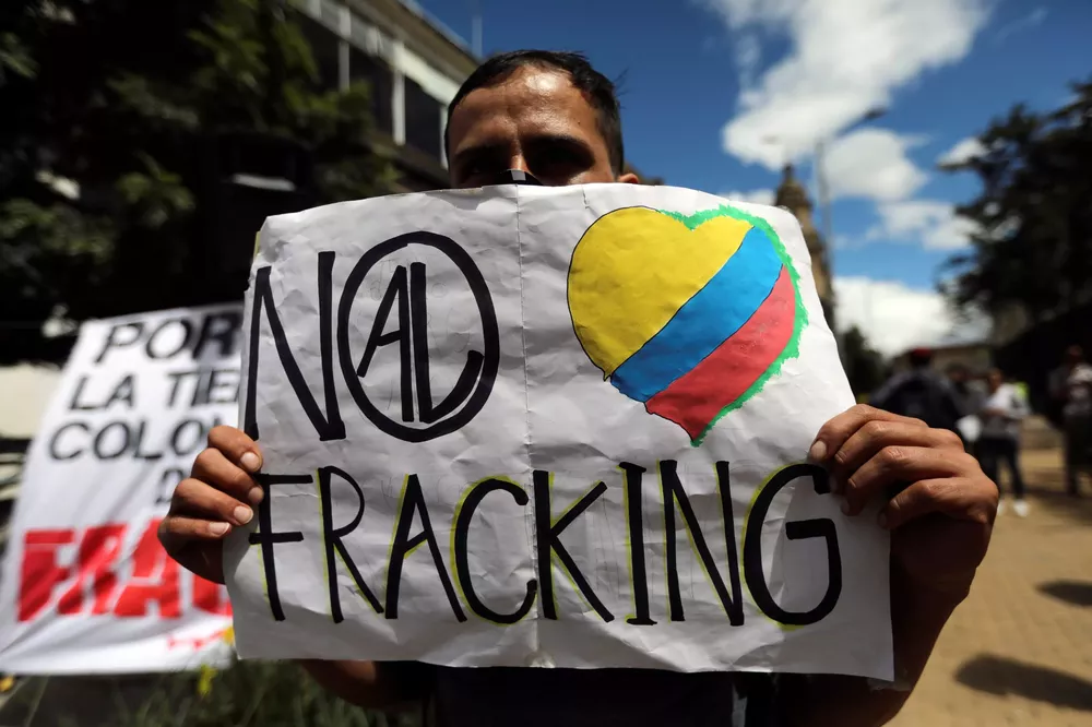 Un-hombre-sostiene-un-cartel-que-dice-No-al-fracking-durante-una-protesta-contra-el-uso-del-fracking-en-Bogota-scaled
