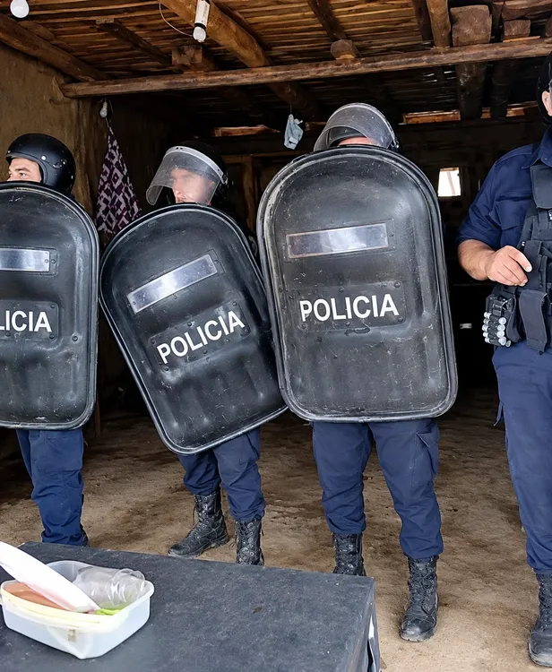 Policías en formación dentro de una cabaña rústica