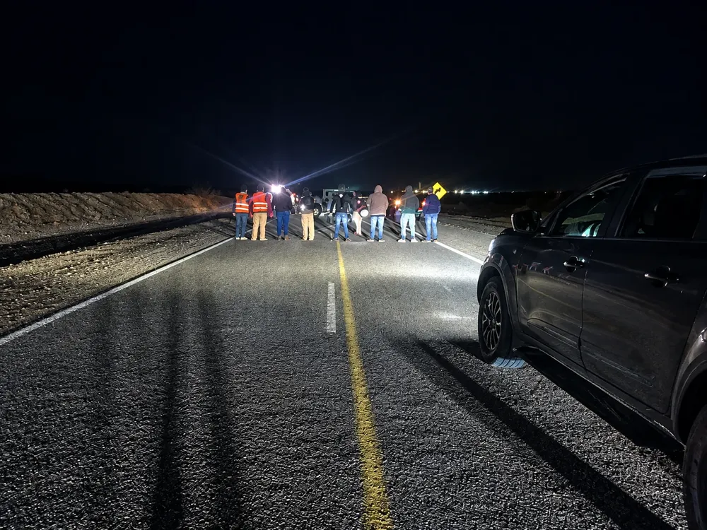 Reunión nocturna en carretera desierta