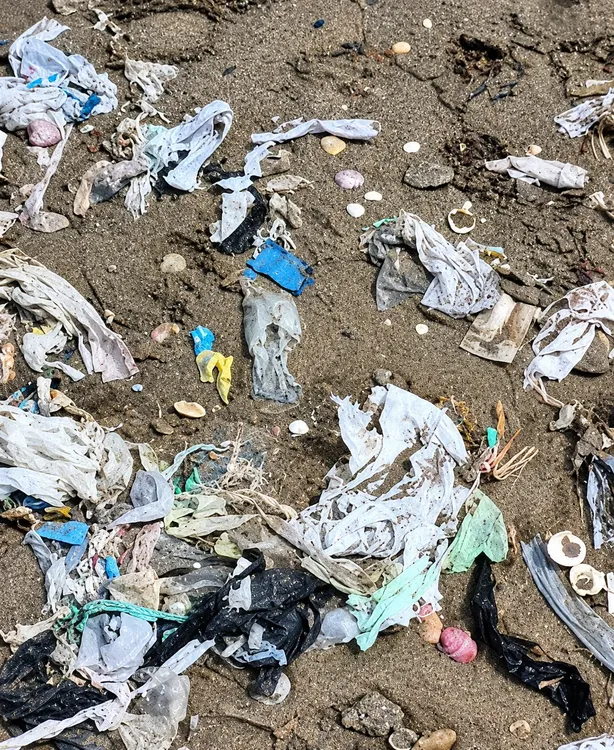 Basura plástica en la orilla de arena